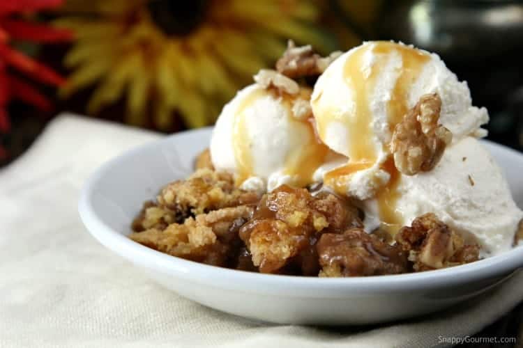 Caramel Apple dump Cake in bowl topped with ice cream