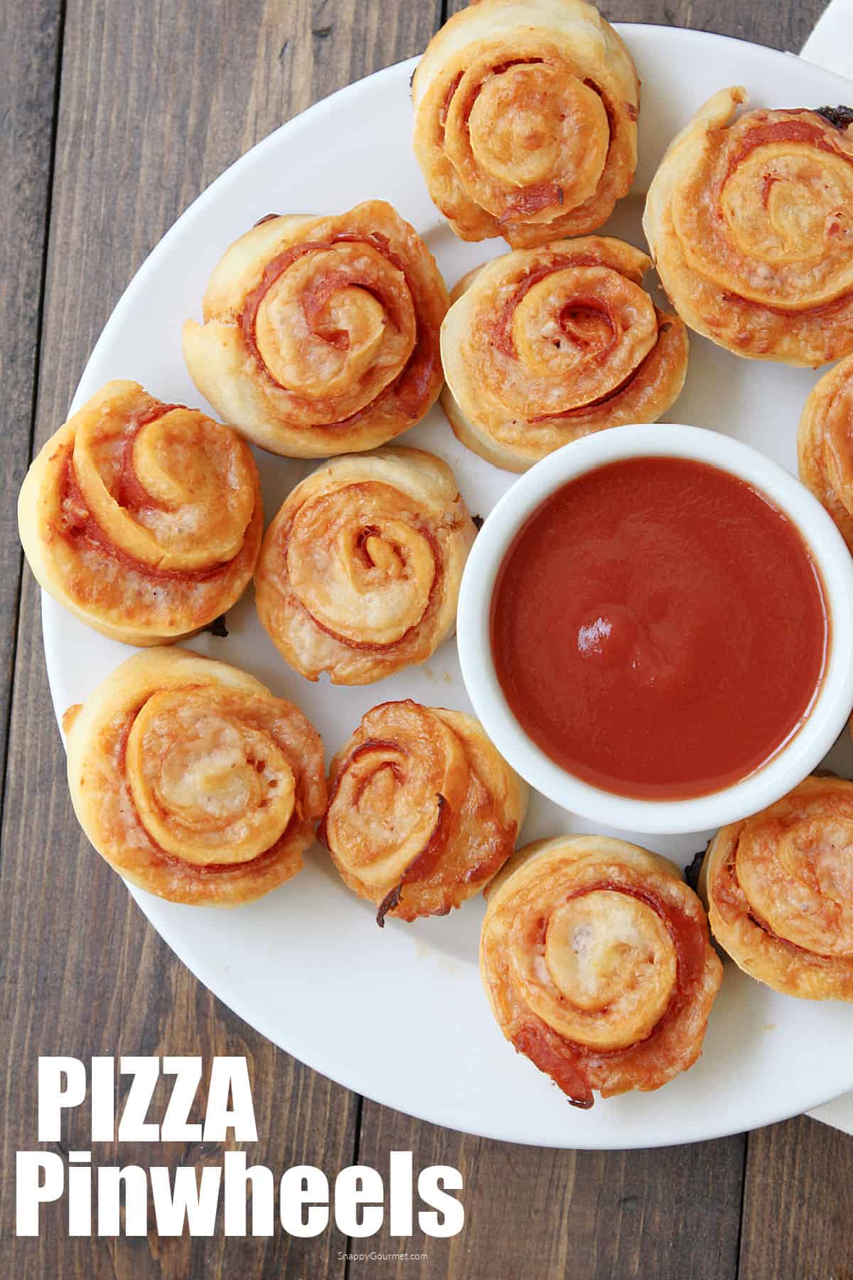 pizza pinwheels on plate with bowl of marinara sauce