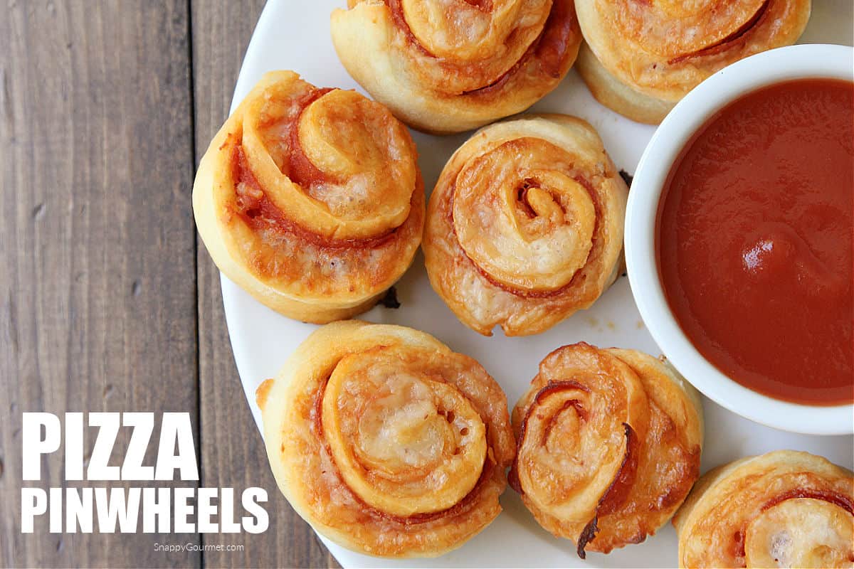 pizza pinwheels on plate with bowl of marinara sauce