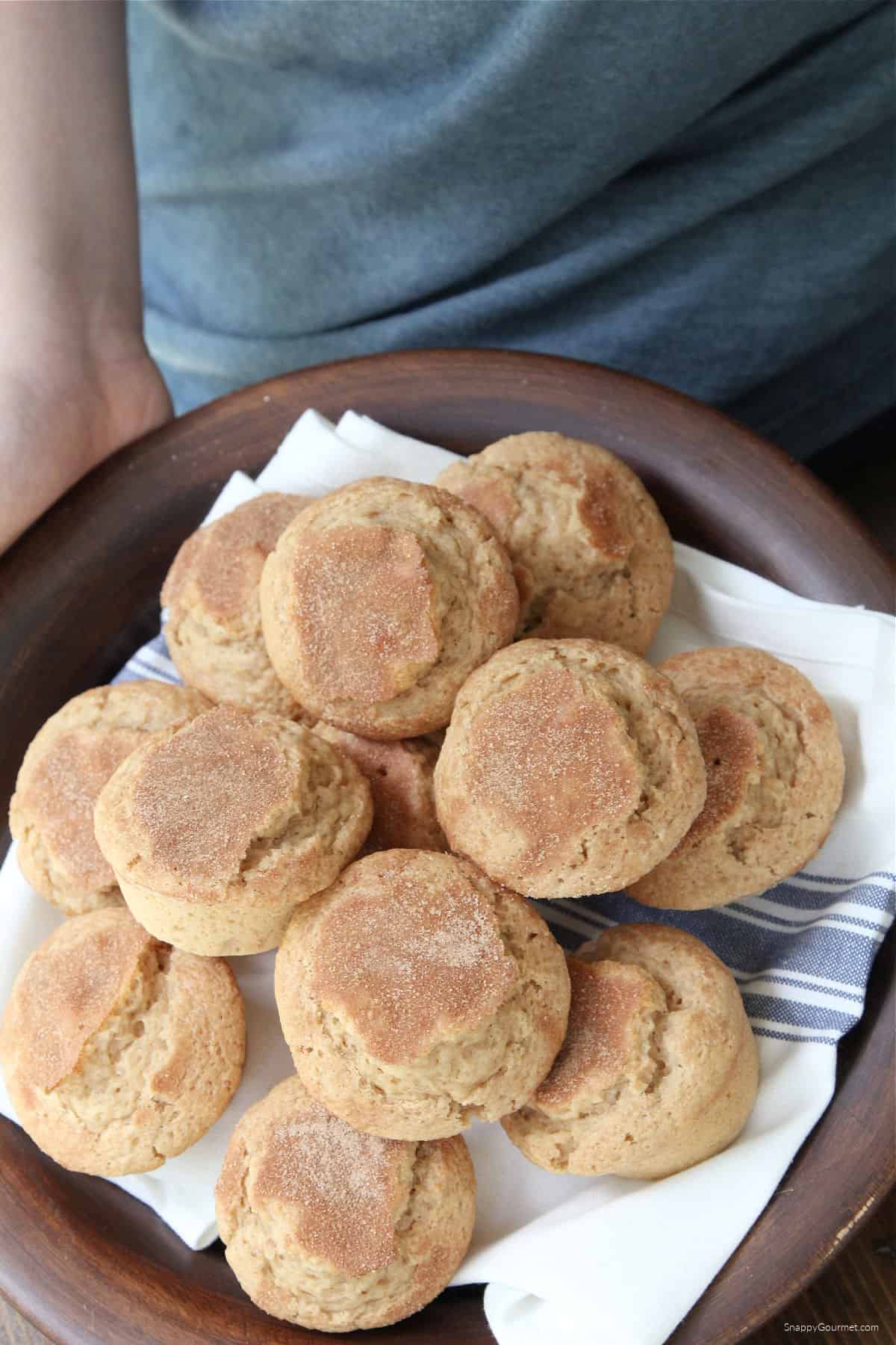 person holding plate of cinnamon muffins