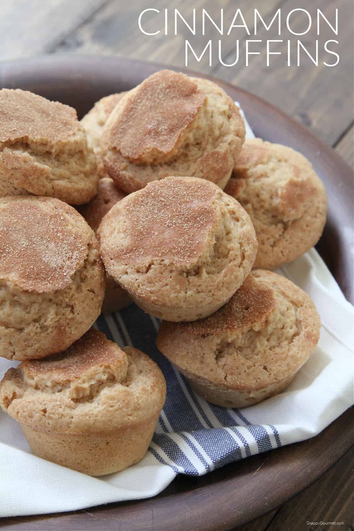 plate with towel and topped with stack of cinnamon muffins