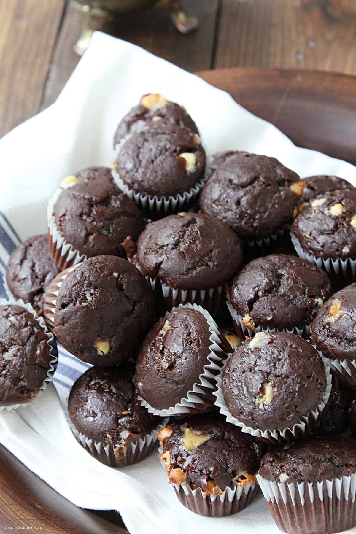 stack of mini chocolate chocolate chip muffins on towel
