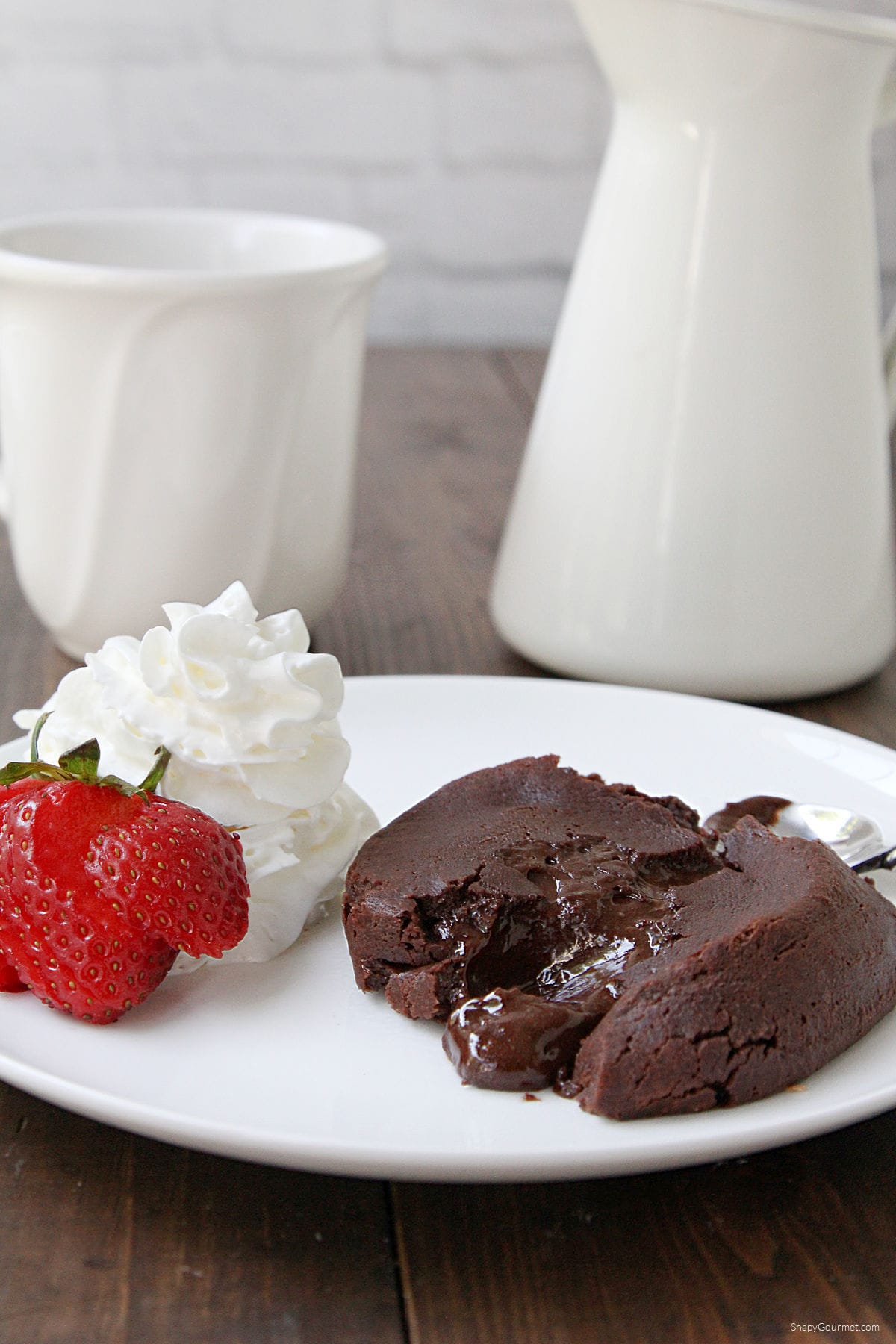 Chocolate Molten Lava Cake on plate with strawberry and whip cream