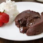 Chocolate Molten Lava Cake with spoon, strawberry, and whipped cream on plate