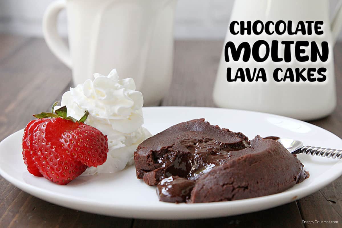 Chocolate Molten Lava Cake on plate with spoon, strawberry and whipped cream and coffee mug in back
