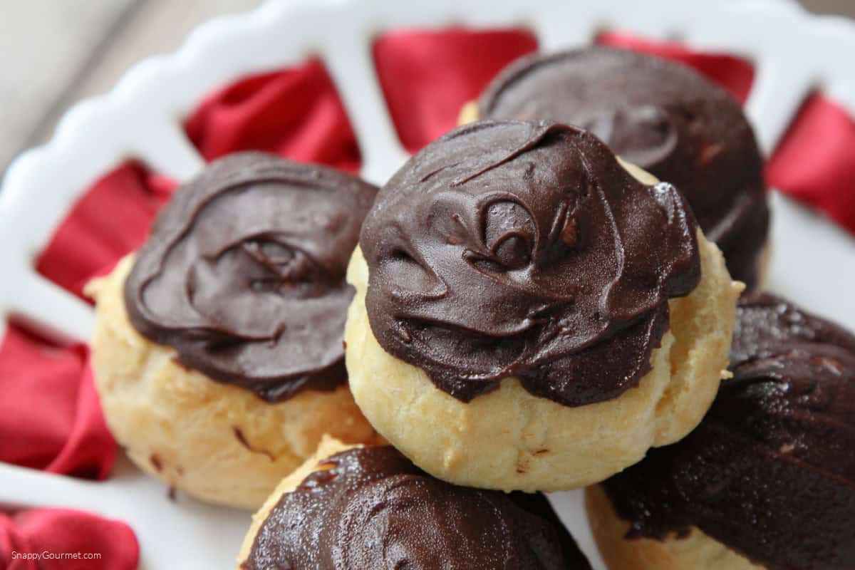 chocolate dipped Profiteroles stacked on plate