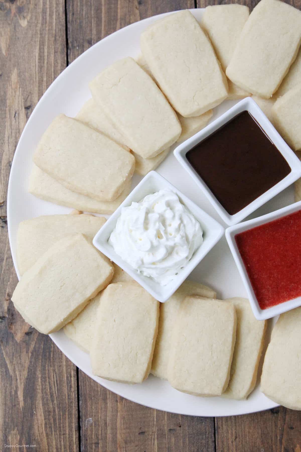 homemade Shortbread Cookie Sticks on plate with three dipping sauces in small bowls