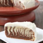 slice of Zebra Cake with cake on stand in background