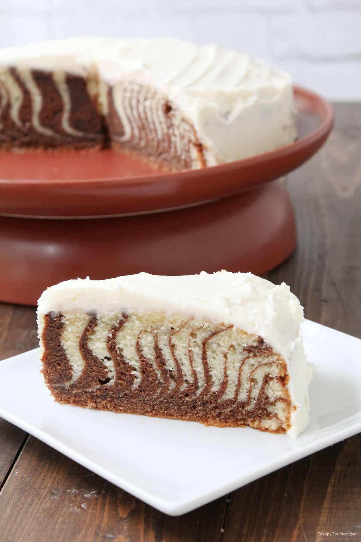 slice of Zebra Cake with cake on stand in background
